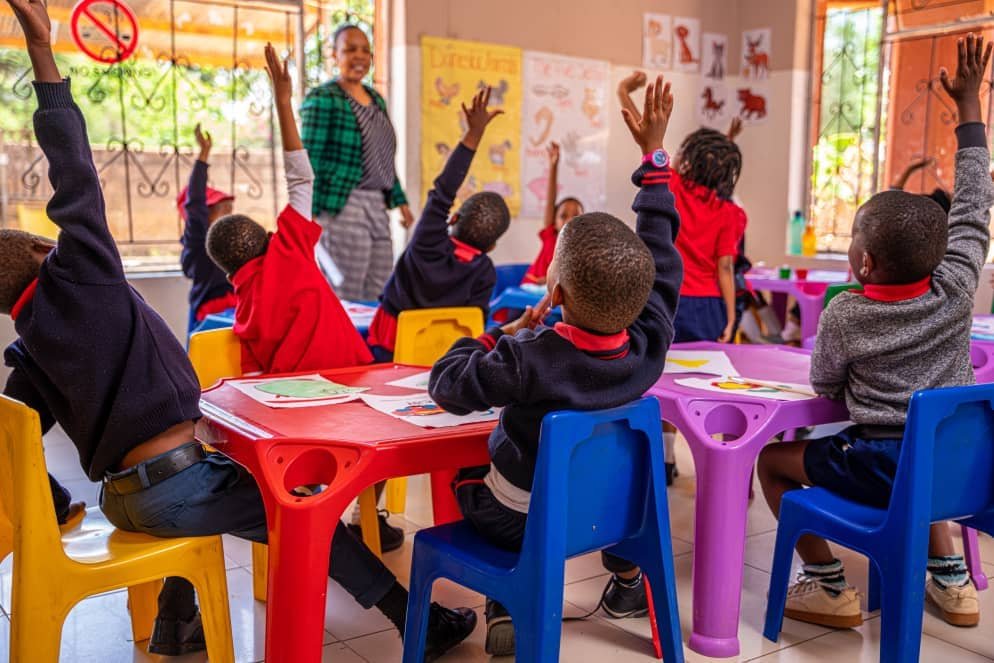 Children raising hands to answer a question